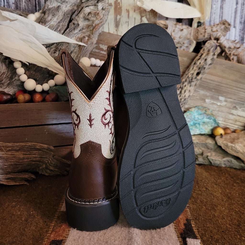 Brown cowgirl boot with dark brown toe and white shaft featuring intricate brown stitching and rubber sole.