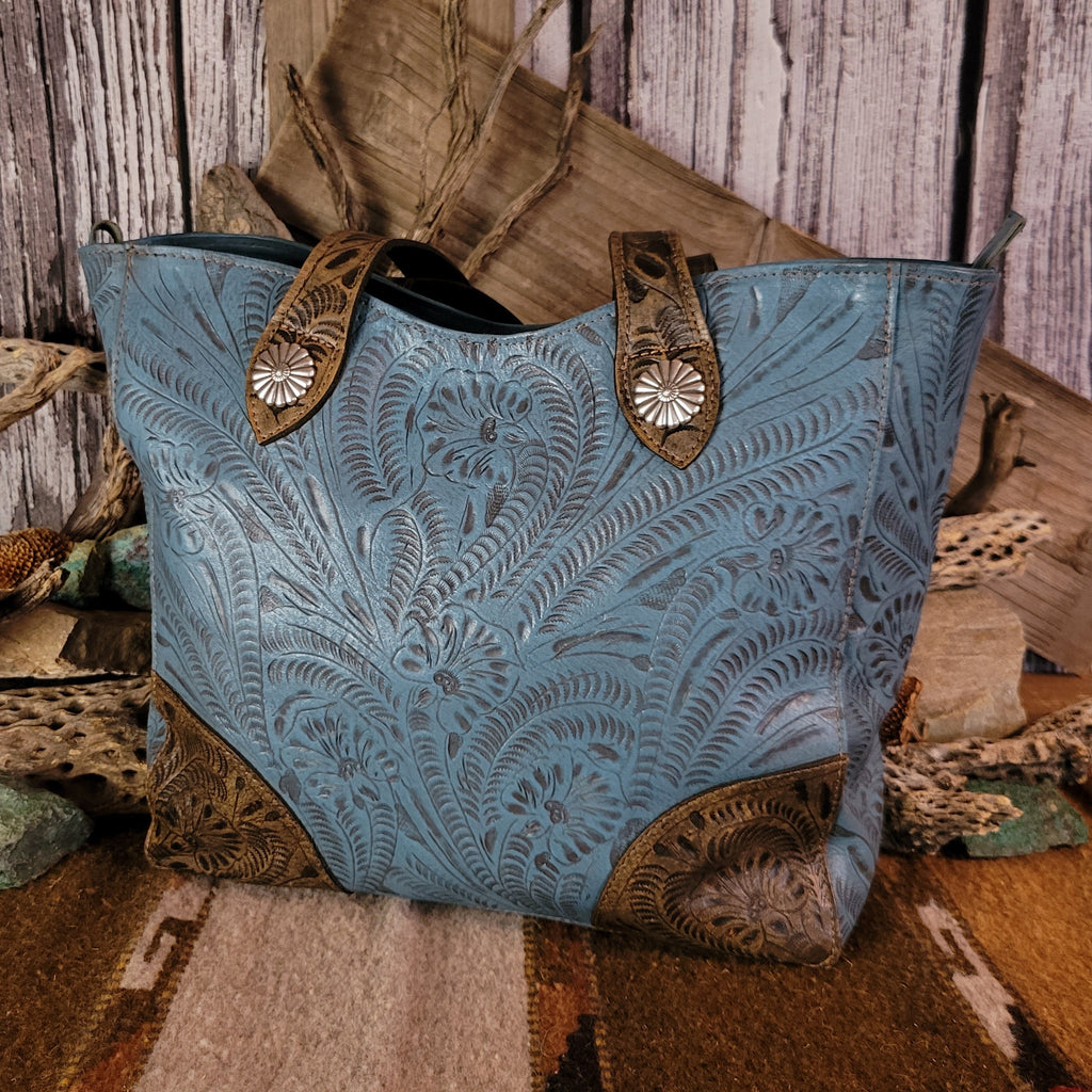 Blue leather purse with floral designs and dual-concealed carry pockets.