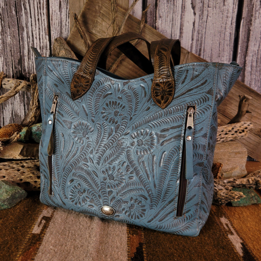 Blue leather purse with floral designs and dual-concealed carry pockets.
