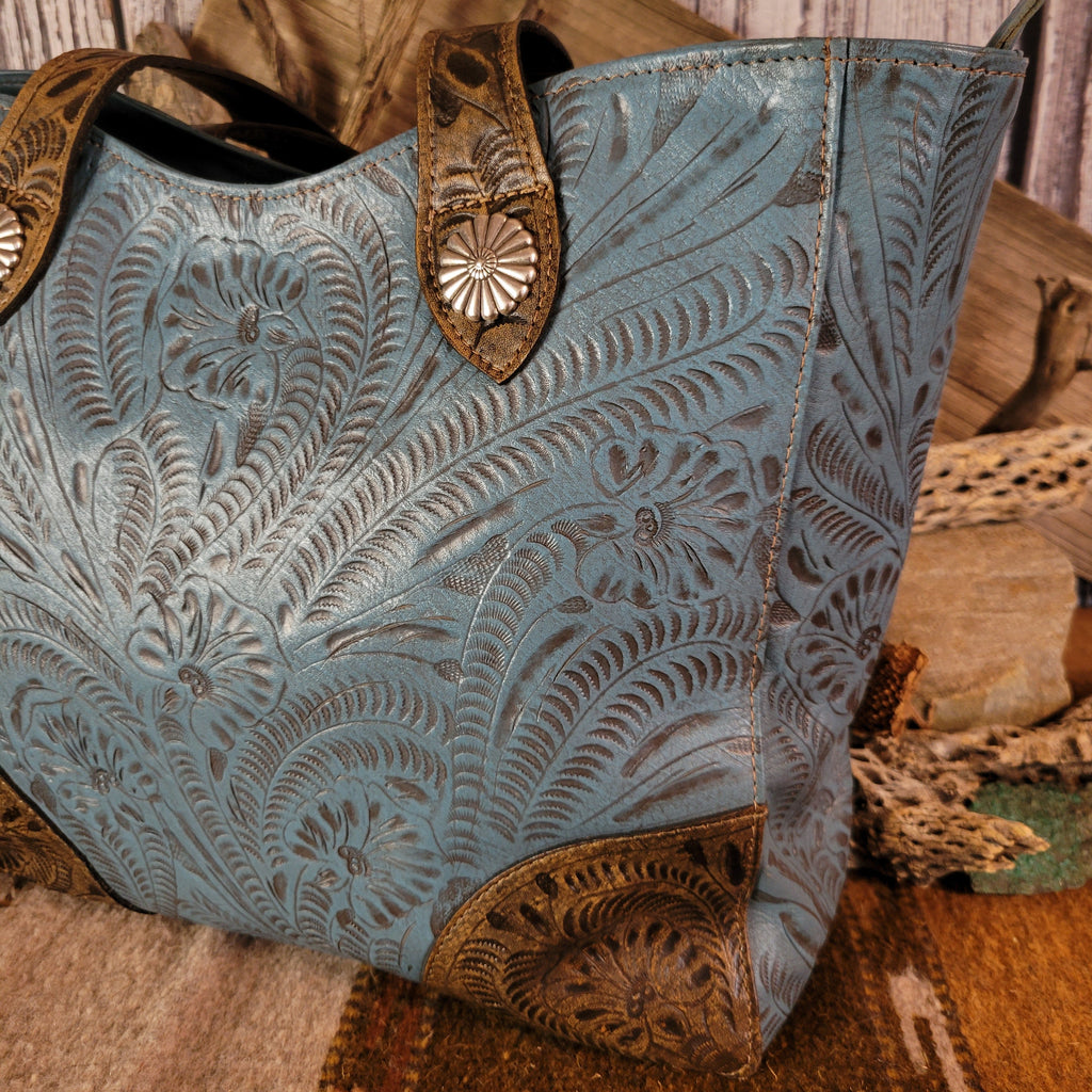 Blue leather purse with floral designs and dual-concealed carry pockets.