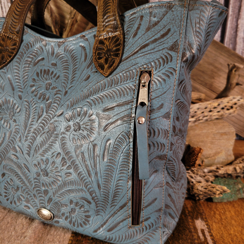 Blue leather purse with floral designs and dual-concealed carry pockets.