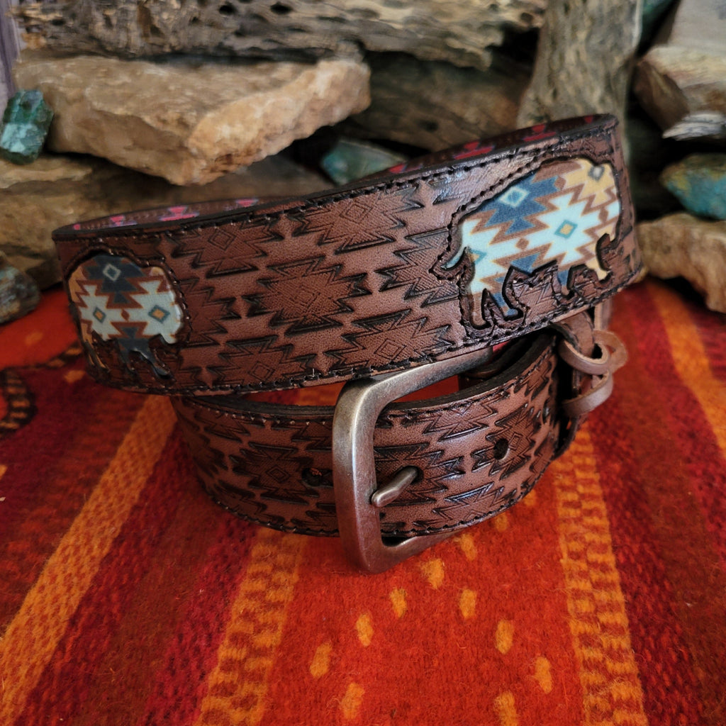 A rich brown leather belt with intricate tooled patterns and Aztec buffalo inlay.
