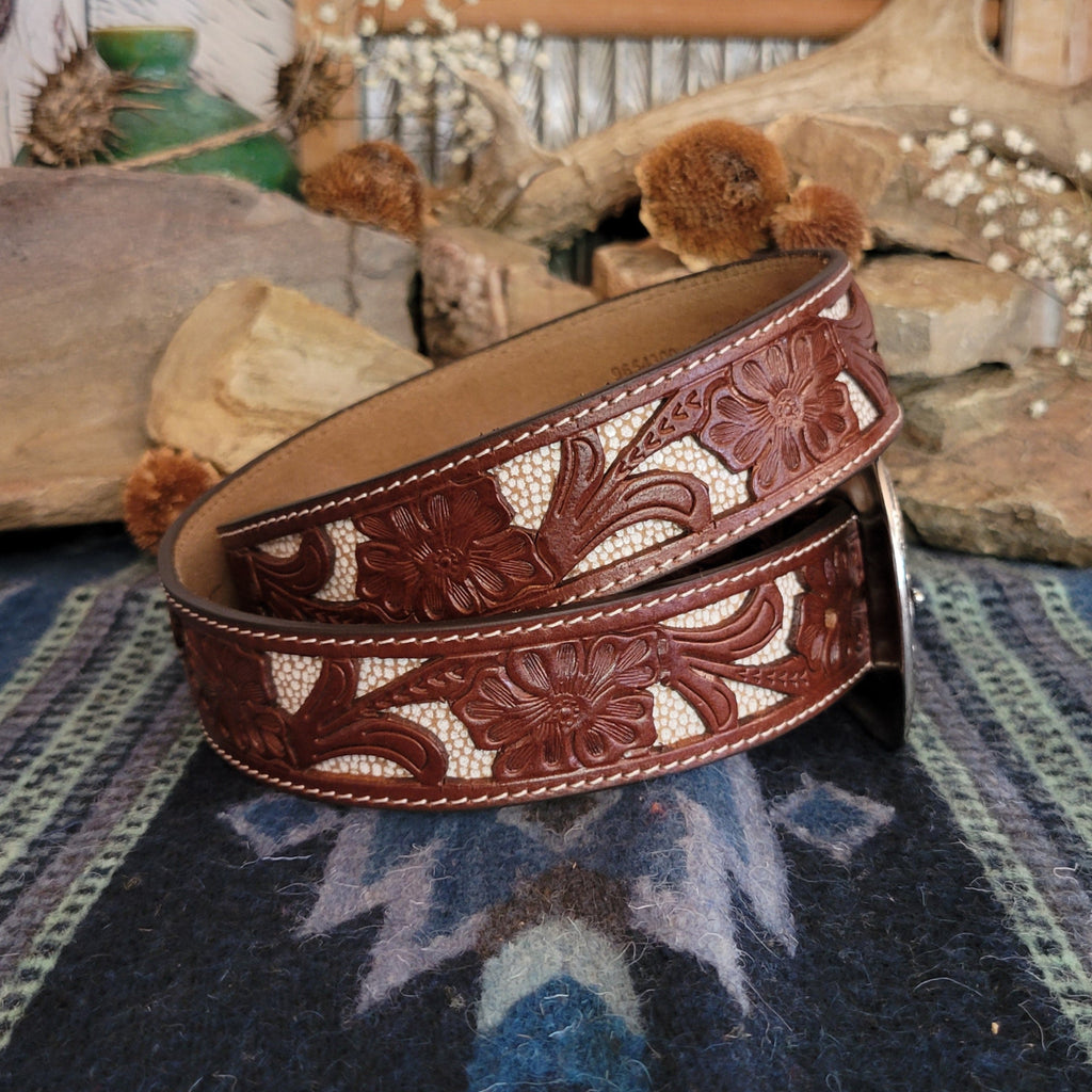Leather belt in rich brown with tooled floral designs and cream inlays.