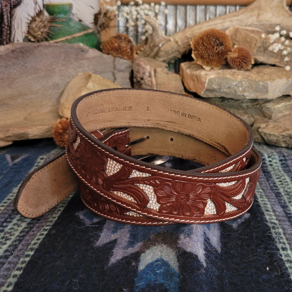 Leather belt in rich brown with tooled floral designs and cream inlays.