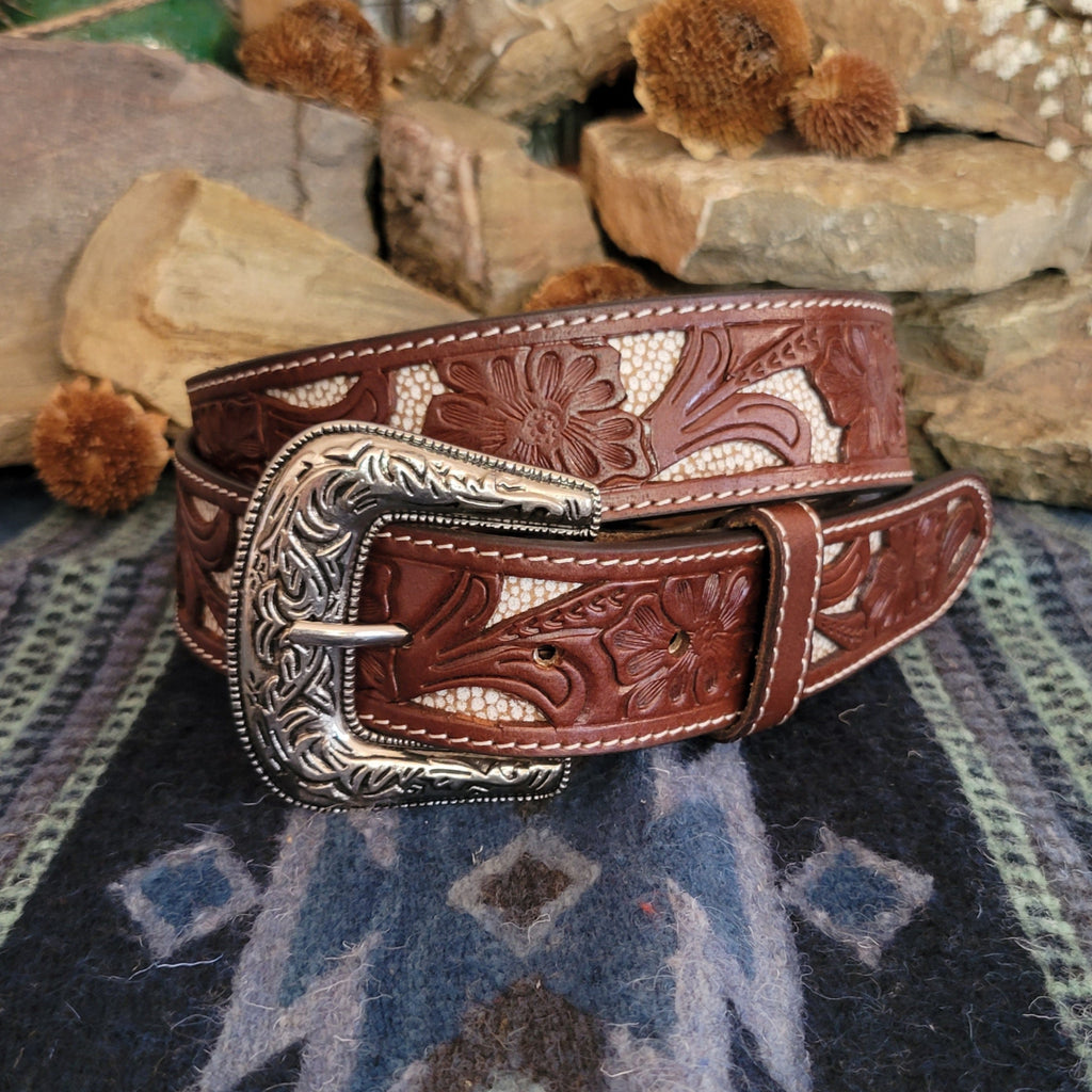 Leather belt in rich brown with tooled floral designs and cream inlays.