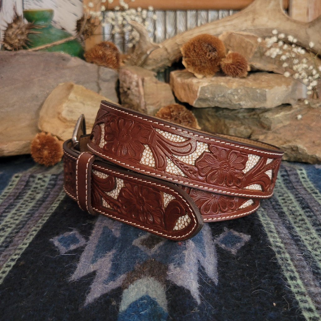 Leather belt in rich brown with tooled floral designs and cream inlays.