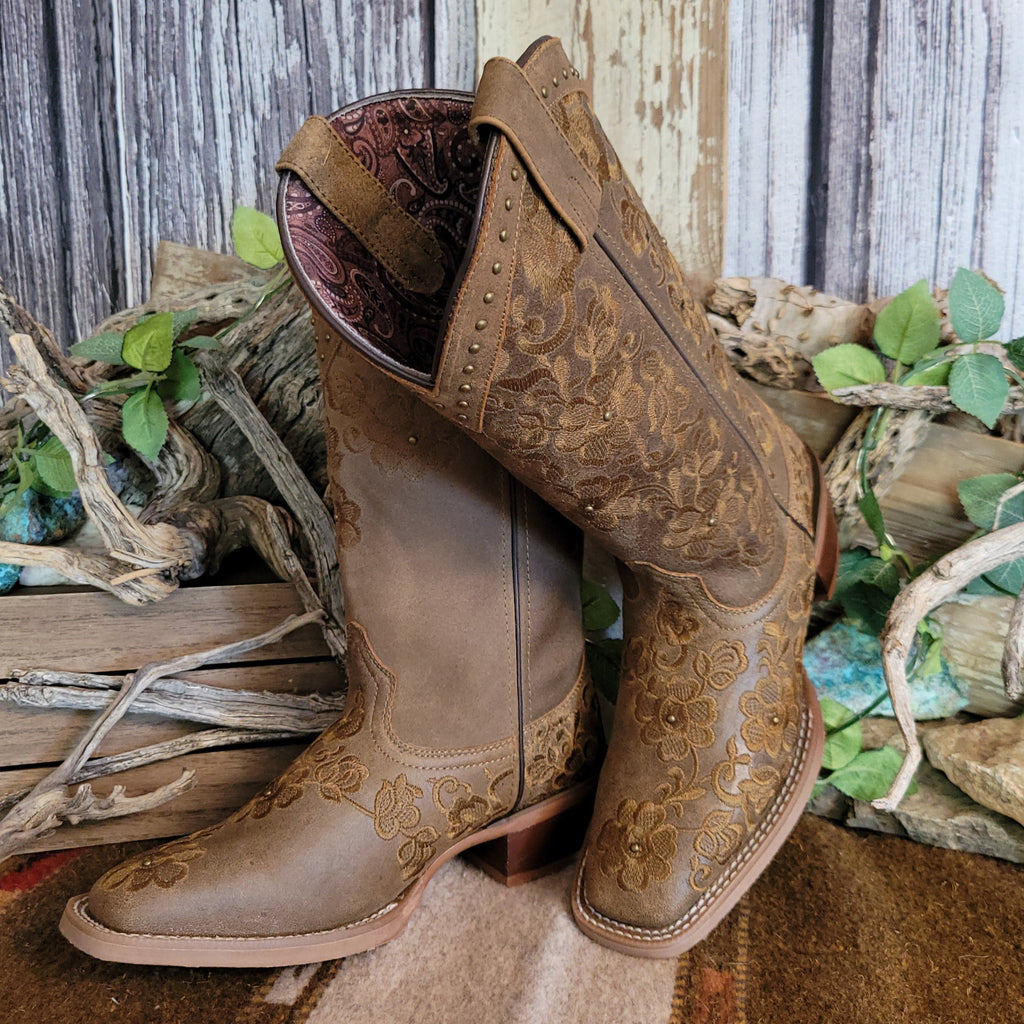 Brown leather boots with intricate floral stitching and decorative studs.