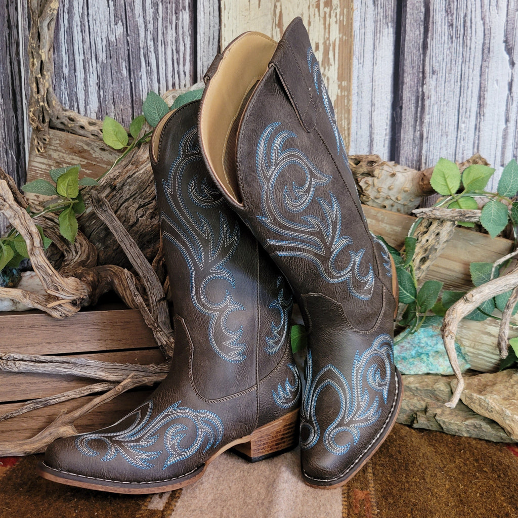 Dark brown faux leather snip toe boot with blue and white stitching along the shaft and toe.