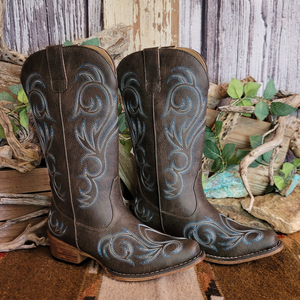 Dark brown faux leather snip toe boot with blue and white stitching along the shaft and toe.