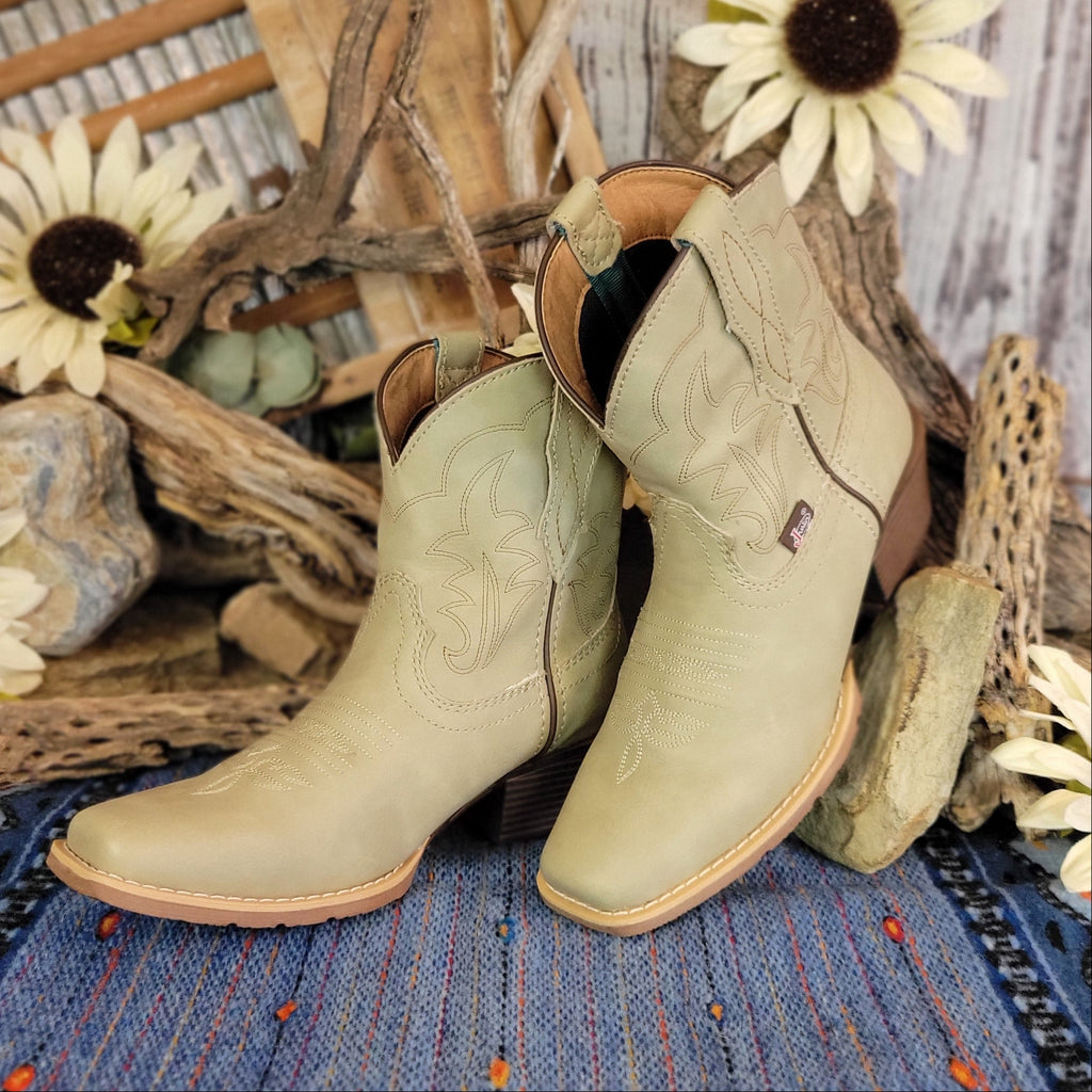 Pair of beige, leather ankle boots with western stitching.