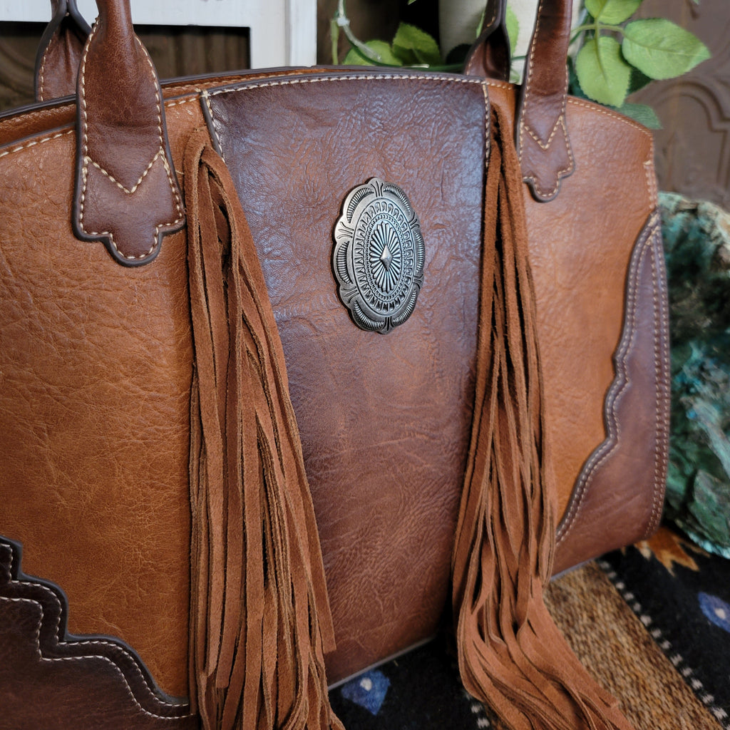 Close up of tassels and silver concho.