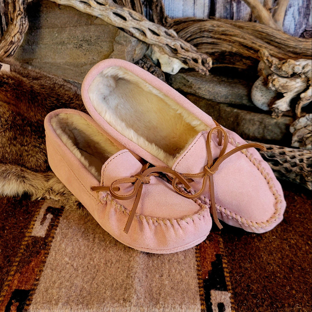 Pair of pink moccasins with pile lined interior, rawhide lace, and soft sole exterior.