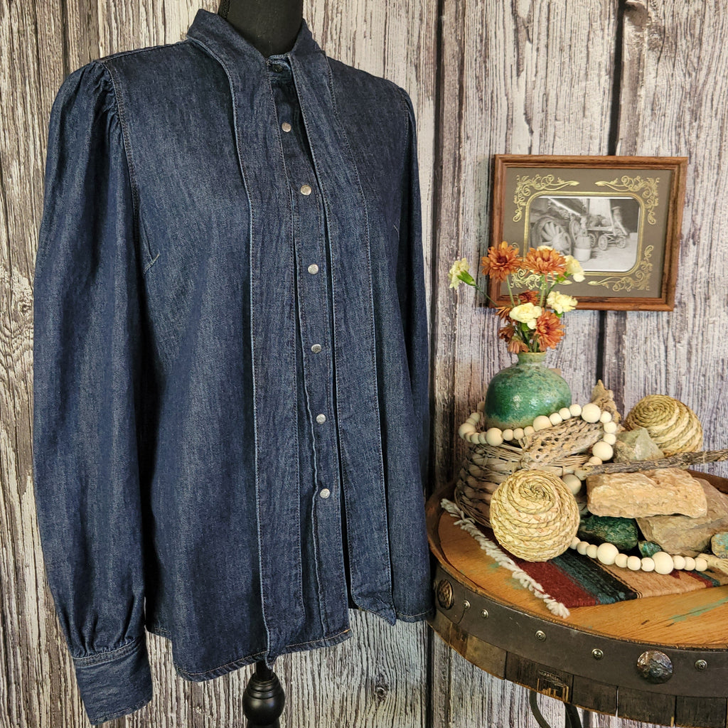 Denim shirt jacket with the tie collar undone and snap buttons.