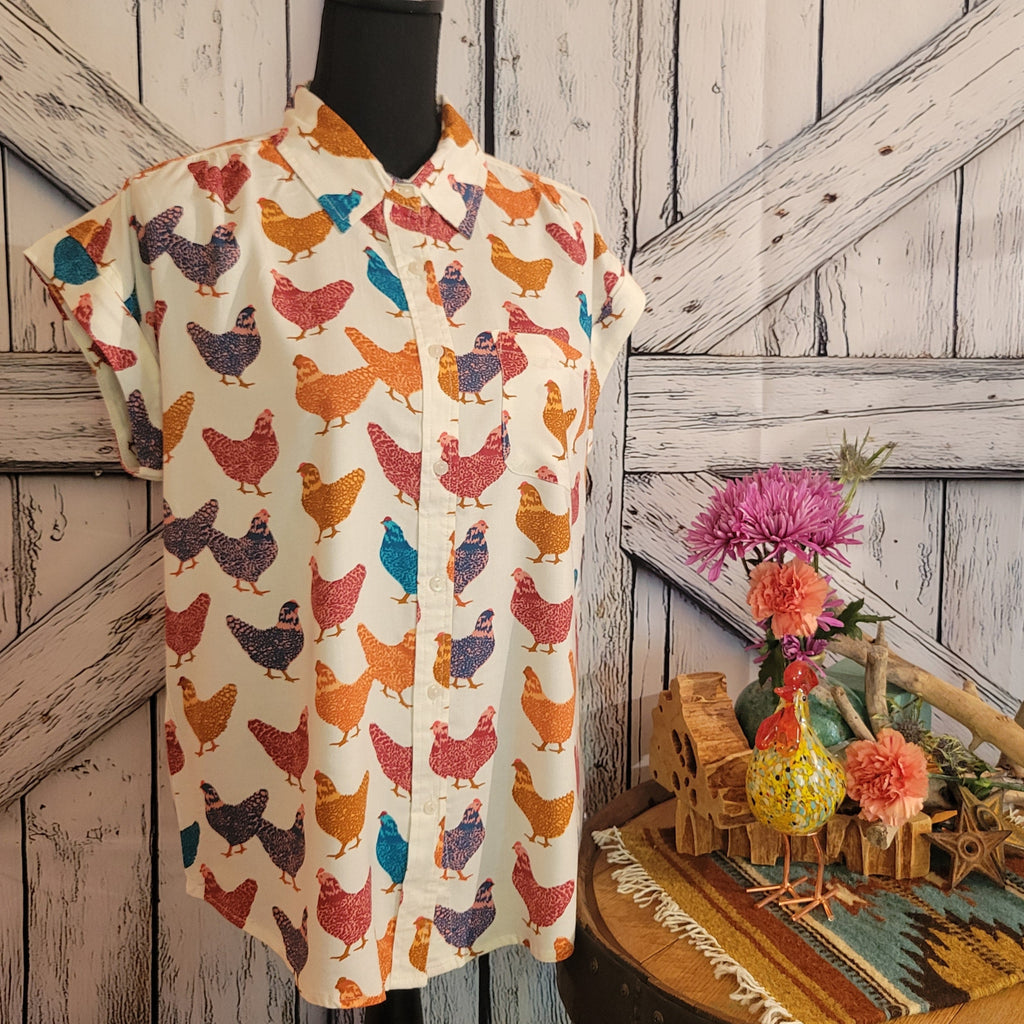 Cream shirt with colorful hen pattern.