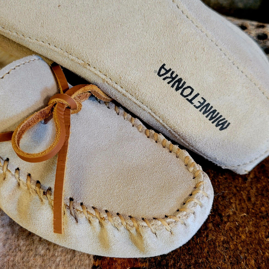 Close-up of the rawhide laces and soft sole exterior with brand name.