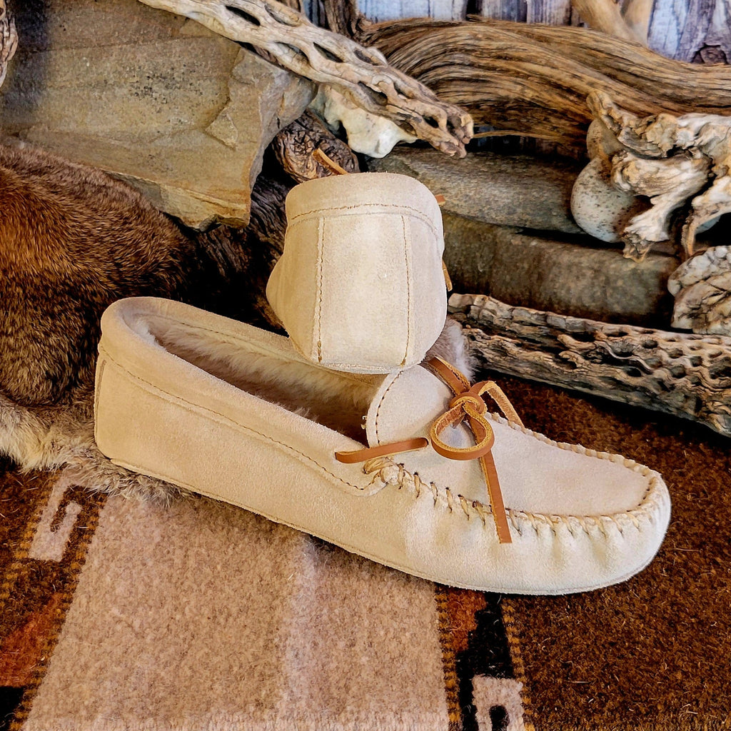 Pair of cream colored moccasins with pile lined interior and rawhide laces.