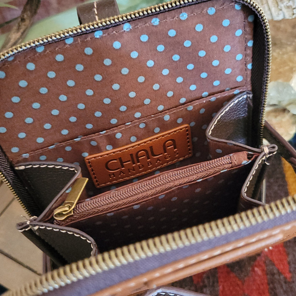 The interior reveals a brown fabric lining with blue polka dots, multiple card slots, and a zippered pocket.