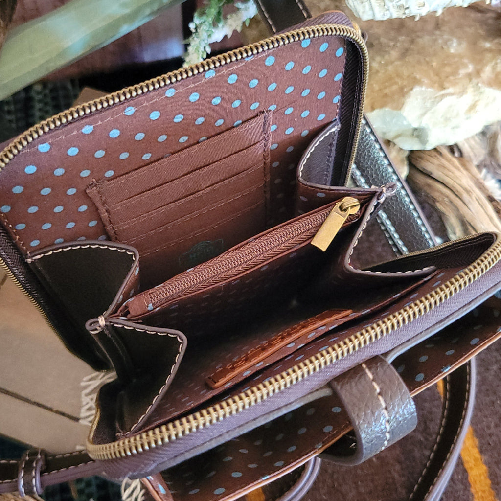 The interior reveals a brown fabric lining with blue polka dots, multiple card slots, and a zippered pocket.