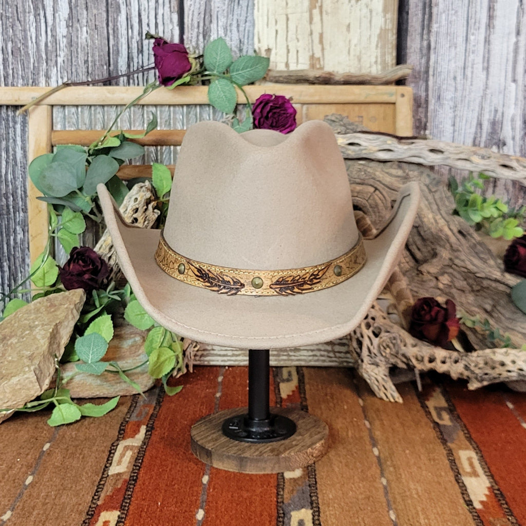 Tan wool felt hat featuring a leather band adorned with conchos and a branded feather design.