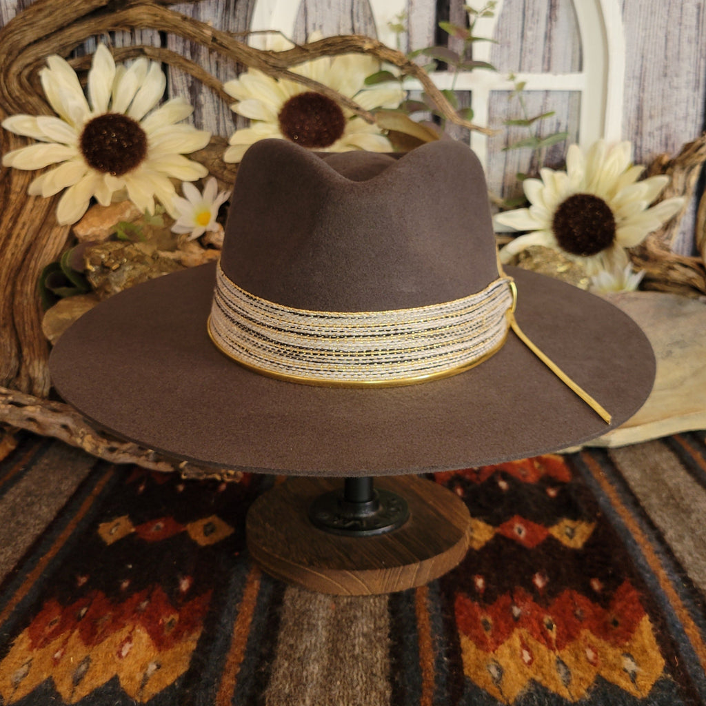 Brown cowgirl hat with decorative tan band.