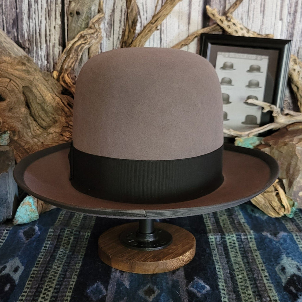 Gray wool hat with large black band and bow featuring a gold concho.