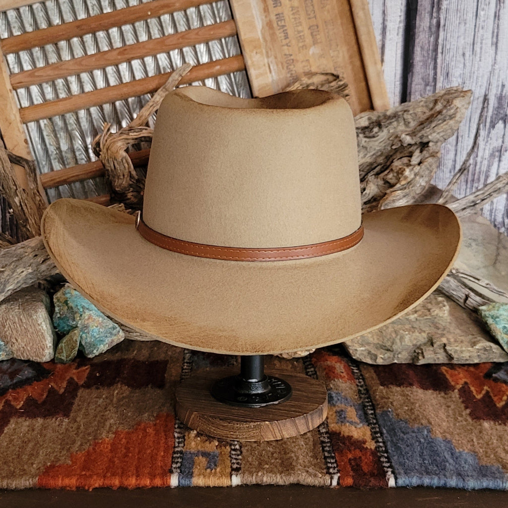 Brown cowboy hat with distressed appearance and a leather hat band.