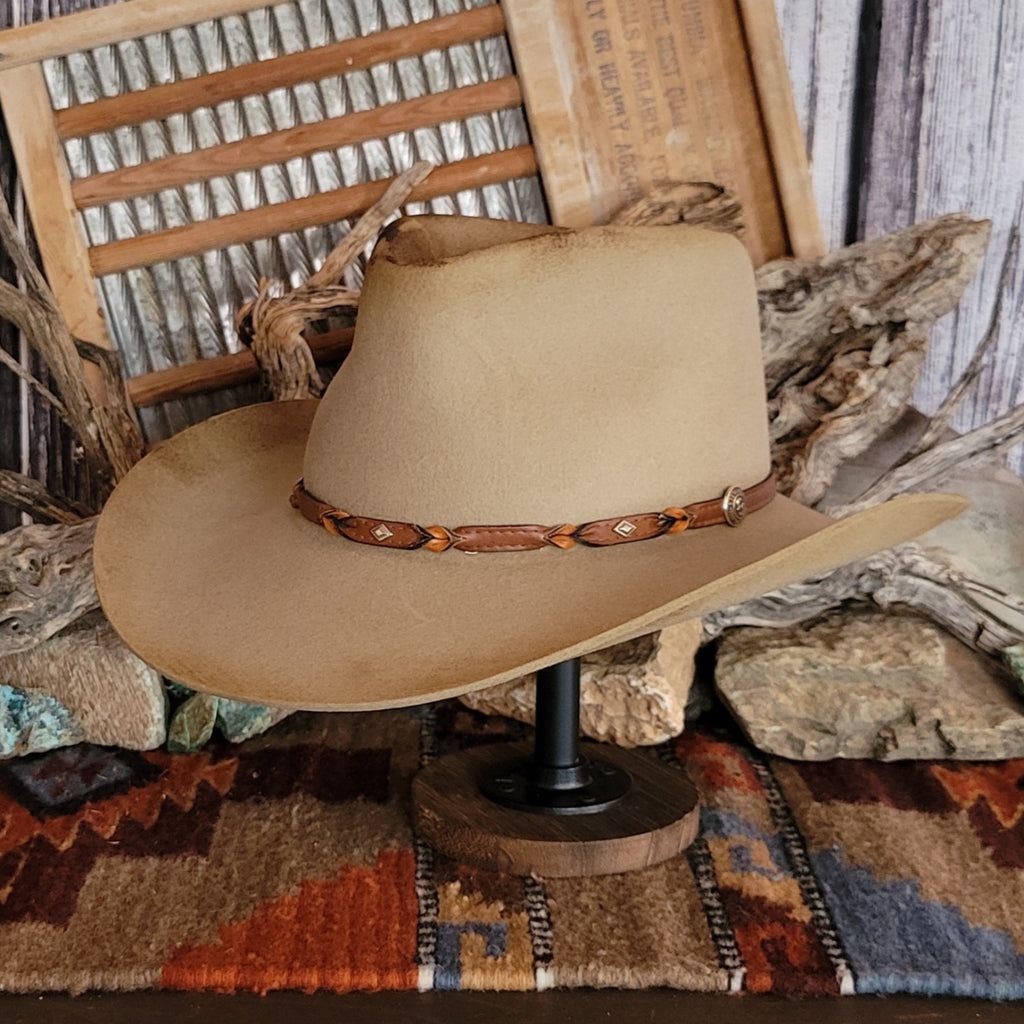 Brown cowboy hat with distressed appearance and a leather hat band.