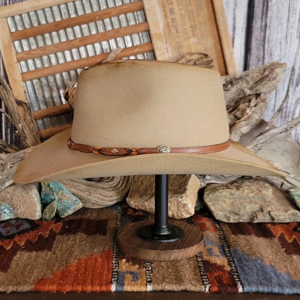 Brown cowboy hat with distressed appearance and a leather hat band.