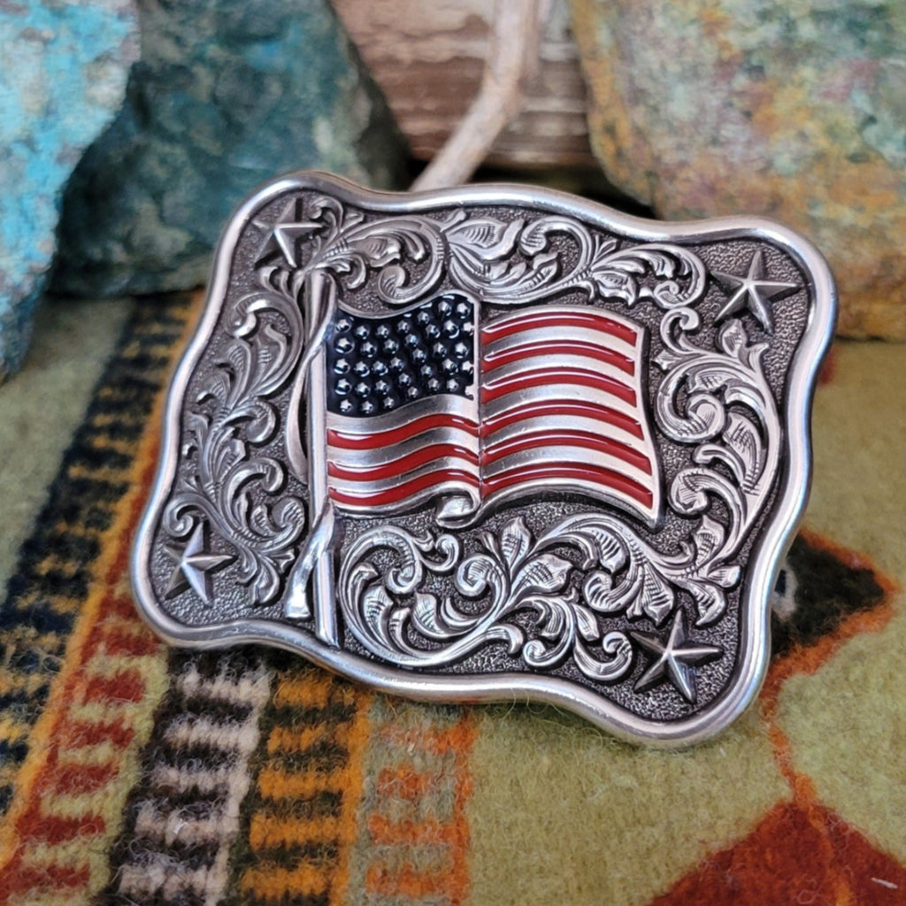 Decorative belt buckle with American flag design and ornate detailing.