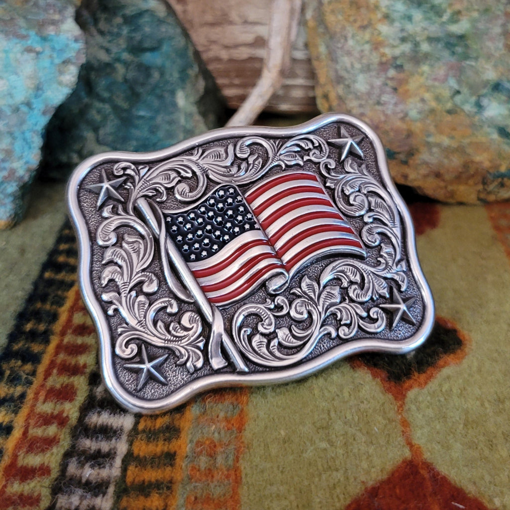 Decorative belt buckle with American flag design and ornate detailing.