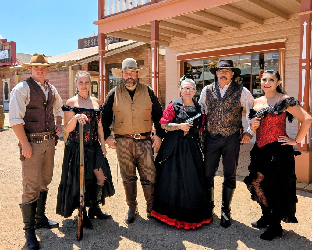 Ladies from The Branding Iron staff dressed in old west attire standing with Tombstone, AZ street actors.